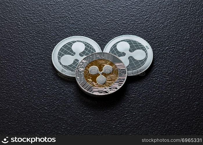 The back and front of the silver ripple coins on a black background. Conceptual image for worldwide cryptocurrency and digital payment system. Top view. Coins of crypto currency ripple isolated on a dark background. Business and technology concept. Top view