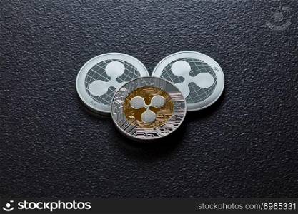 The back and front of the silver ripple coins on a black background. Conceptual image for worldwide cryptocurrency and digital payment system. Top view. Coins of crypto currency ripple isolated on a dark background. Business and technology concept. Top view
