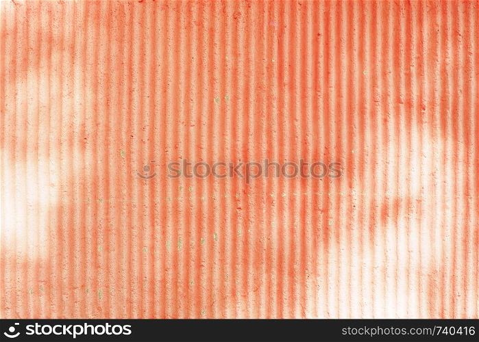 The background and texture of the ribbed concrete wall is unevenly painted in coral color.