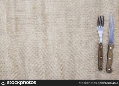 The background for the menu. Canvas tablecloth and fork and steak knife. Is used to create a menu for a Steakhouse.. Canvas tablecloth and fork and steak knife. Is used to create a menu for a Steakhouse. The background for the menu.