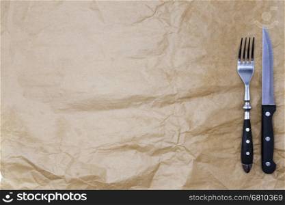 The background for the menu. Wrapping paper and a fork and a steak knife. Is used to create a menu for a Steakhouse. Good background to create restaurant menus, cafes bars.