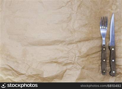 The background for the menu. Wrapping paper and a fork and a steak knife. Is used to create a menu for a Steakhouse. Good background to create restaurant menus, cafes bars.