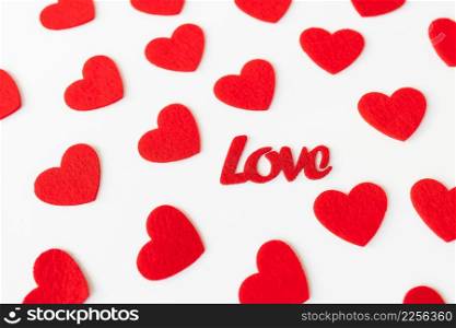 The background which consists of red hearts, the inscription love in the middle of the hearts. Love concept, greeting card for valentine&rsquo;s day. The background which consists of red hearts, the inscription love in the middle of the hearts. Love concept, greeting card for valentine&rsquo;s day.