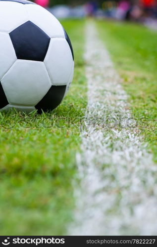 The ball in grass. The sideline. Fresh green grass. Black and white ball.