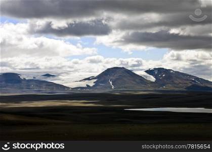 The barren tundra of the Sprengisandur Highlands in Iceland, with the dominating Vatnajokull glacier in the background