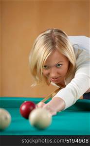 The beautiful blonde aims in a billiard sphere. Billiards