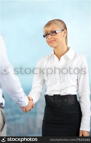 The beautiful business lady shakes hands with someone at office