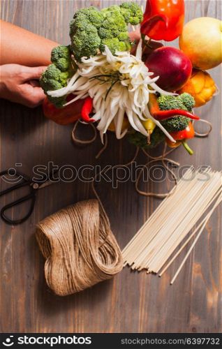 The beautiful food - edible bouquet with carved fruit flowers and vegetables in rustic style. Vegetable and fruit carving