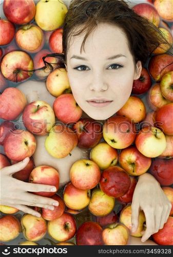 The beautiful girl floating in apples photo