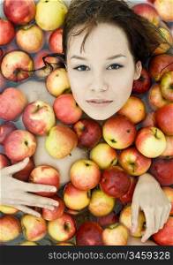 The beautiful girl floating in apples photo