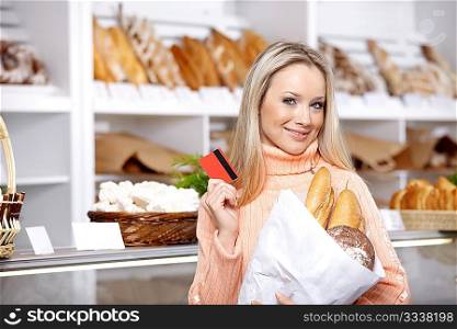 The beautiful girl with a credit card in shop