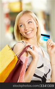 The beautiful girl with purchases and a credit card
