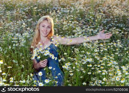The beautiful happy young woman in the field of camomiles