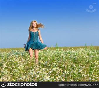 The beautiful happy young woman in the field of chamomiles