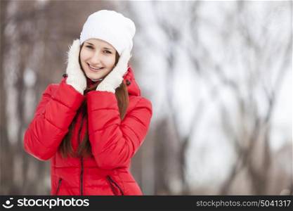 The beautiful smiling woman on walk in winter wood. Winter walk