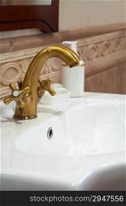 The beautiful water faucet from bronze in a bathroom