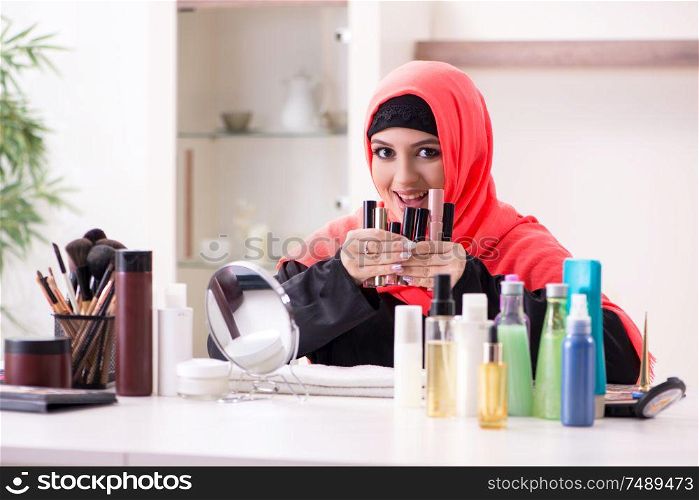 The beautiful woman in hijab applying make-up. Beautiful woman in hijab applying make-up