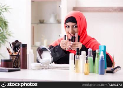 The beautiful woman in hijab applying make-up. Beautiful woman in hijab applying make-up