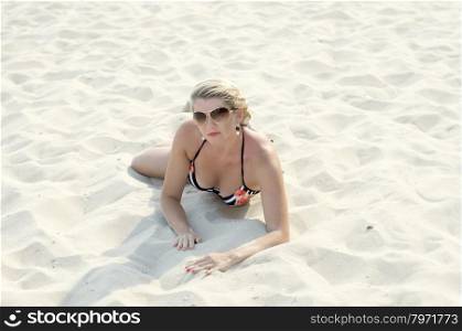 the beautiful woman lies on a beach in sand