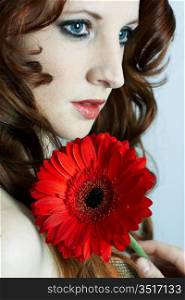 The beautiful young girl with a red flower
