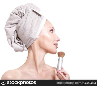 The beautiful young woman in towel with a cosmetic brush