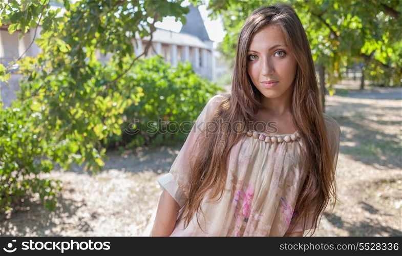 The beautiful young woman with long hair in dress outdoor