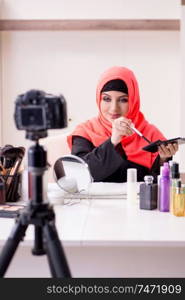 The beauty blogger in hijab recording video for her blog . Beauty blogger in hijab recording video for her blog 