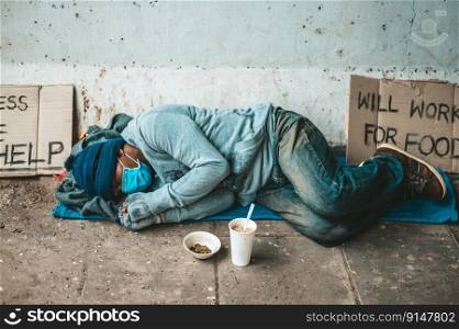 The beggars lay on their side of the street with dirty clothes.