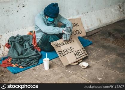 The beggars sat beside the street with a homeless message. Please help and work with food.
