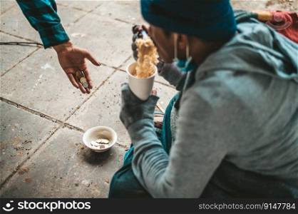 The beggars sat wrapped in cloths and eating noodles.