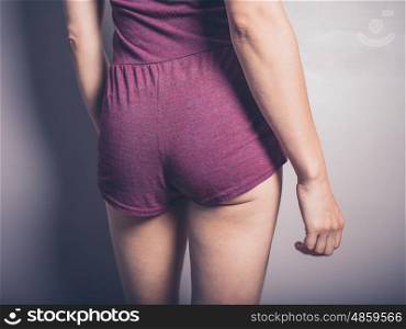 The behind of a young woman wearing purple fitness clothes