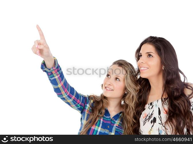 The best friends. Two pretty women indicating something with the finger isolated on a white background
