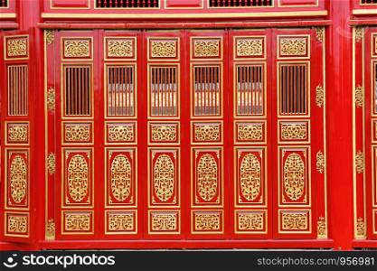 the big red carving wood doors in the HUE Palace