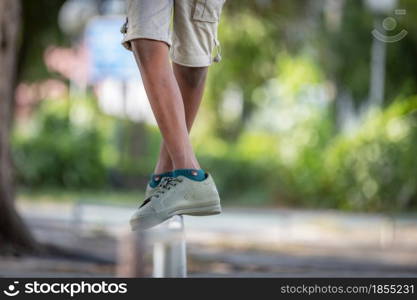 The black boy's legs stood balancing on the iron rod.