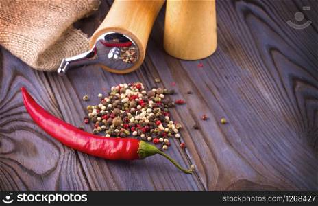 The Black pepper corns, red hot chili pepper and Black pepper Powder on wooden background. Black pepper corns, red hot chili pepper and Black pepper Powder on wooden background.