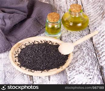 The black sesame and oil on old wooden background