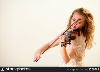 The blonde girl music lover on beach playing the violin. Love of music concept.