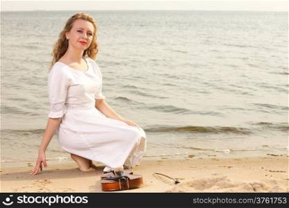 The blonde girl music lover on beach with a violin. Love of music concept.