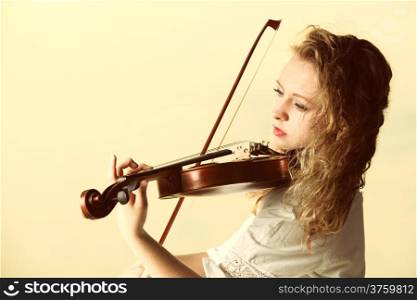 The blonde girl music lover on pier with a violin at sunset or sunrise. Love of music concept.