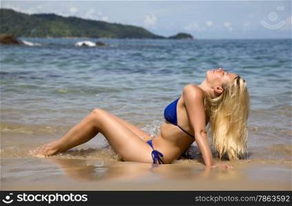 The blonde with long flowing hair on the beach taking a sunbath. Thailand. Phuket