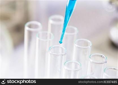 The blue drop from pipette in laboratory tubes. The Laboratory tubes