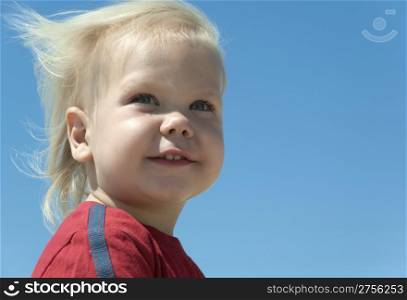 The blue-eyed boy with blond hair developing on a wind