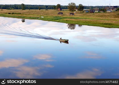 The boat floats down the river on a sunset