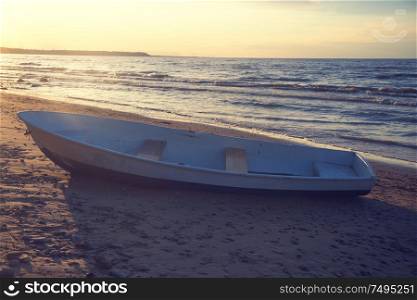 the boat stands on the shore by the sea