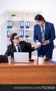 The boss and his male assistant working in the office. Boss and his male assistant working in the office