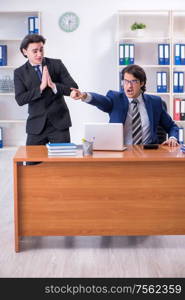 The boss and his male assistant working in the office. Boss and his male assistant working in the office