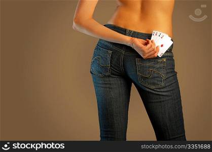 The bottom part of a body of the girl in jeans holding the pack of cards