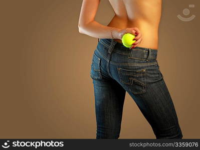 The bottom part of a body of the girl in jeans holding a tennis ball
