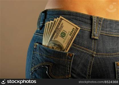 The bottom part of a body of the girl in jeans with a 100 dollar banknotes in a pocket. Currency imaginations