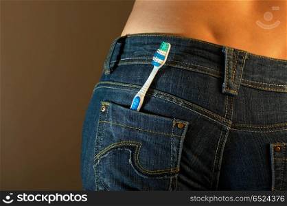 The bottom part of a body of the girl in jeans with a tooth-brush in a pocket. Jeans imaginations